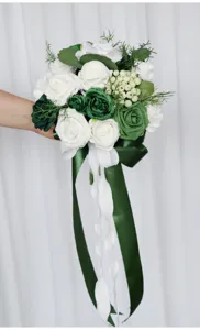 Nahaufnahme des weiß-grünen künstlichen Rosenhochzeitsstraußes mit schöner Banddekoration.