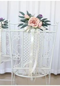 Detail view of wedding chair back floral decoration with pink artificial roses and ribbons.