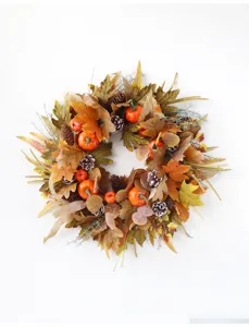 Autumn wreath detail showing rich maple leaves, natural pinecones, and cute mini pumpkins.