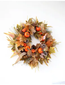 Autumn artificial wreath with maple leaves, pine cones and pumpkins for holiday wall decor.