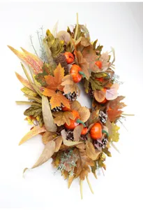 Exquisite autumn wreath detail featuring maple leaves, pine cones, and vibrant orange pumpkins.