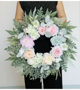 Detail shot of artificial peony rose wreath with eucalyptus leaves, perfect for home decor.