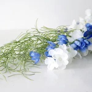 Kaskadierender künstlicher Hochzeits-Brautstrauß mit blau-weißen Blumen und grünem Laub.