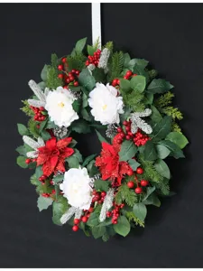 Detailed closeup of artificial Christmas wreath with white flowers, red berries and pine needles.