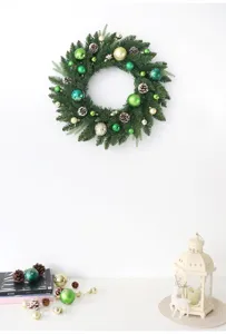 Detailansicht des Weihnachtskranzes mit Tannenzapfen und dekorativen Christbaumkugeln.