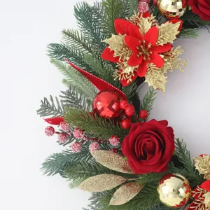 Christmas artificial wreath with red roses, gold baubles and pine needles for door decor.