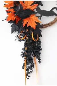 Halloween wreath detail featuring black crow, cat silhouette, and orange maple leaves for party.