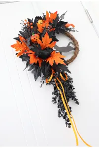 Halloween wreath detail showing black leaves, crow, and cat silhouette for party decor.