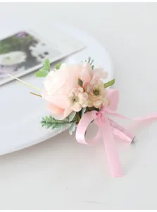 Pink artificial flower boutonniere detail shot, elegant wedding corsage with ribbon bow.