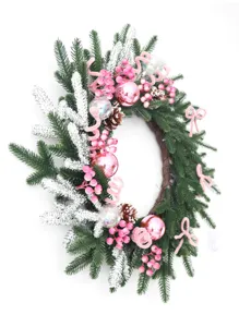 Corona de Navidad rosa y verde con ramas de pino nevadas, bolas y bayas para la puerta.