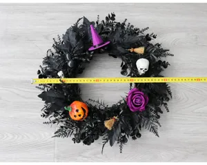 Halloween zwarte krans decoratie met heksenhoed schedel pompoen voor deur hangen.