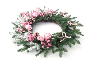 Detalle de corona de navidad con bayas rosas, piñas, lazos y agujas de pino escarchadas.