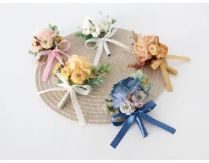 Detailed view of artificial floral boutonnieres with elegant ribbon bows, perfect for weddings.