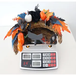Detailed view of Halloween crescent moon cat wreath on scale, showing lightweight design and decor.