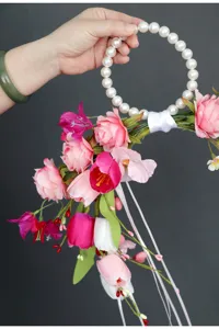 Dettaglio del fiore da polso da sposa artificiale con rose e manico di perle.
