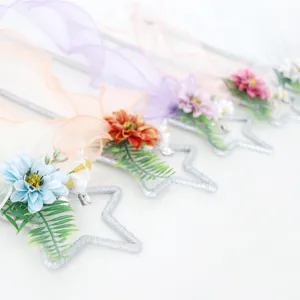 Bacchetta magica a stella scintillante con fiori artificiali e nastri per festa cosplay