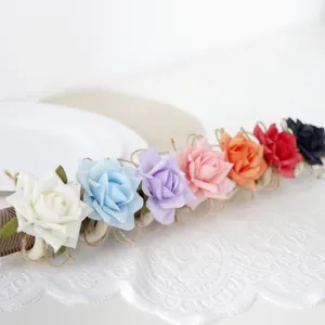 Portaserviettoni con rose artificiali colorate e base in corda di juta per decorazione tavola.
