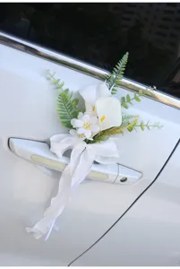 Detail view of white artificial calla lily wedding car door handle flower with bow ribbon.