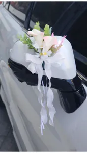 Wedding car mirror floral decoration, artificial flower and bow ribbon detail view.