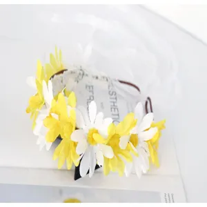 Detailed close-up of artificial white and yellow daisy floral crown with sweet ribbon.