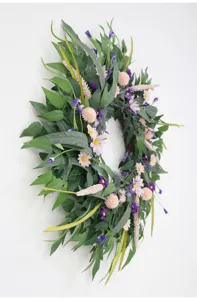 Detailaufnahme des künstlichen Grünblatt- und Kleingänseblümchen-Blumenkranzes für Wand.