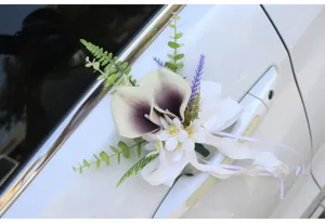 Detailed close-up of artificial wedding car door handle flower with calla lilies and ribbons.