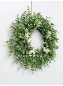 Eucalyptus wreath detail showcasing lush greenery and delicate white flowers for home decor.