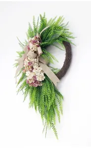 Detailed view of the artificial fern and hydrangea wreath with elegant burlap bow.