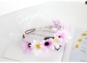 Close-up detail of a fairy floral headband with pink white daisies and soft white ribbons.