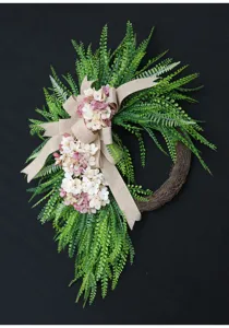 Artificial floral door wreath with fern leaves hydrangeas and burlap bow for home decor.