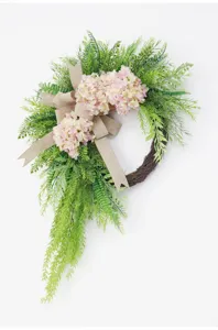 Artificial hydrangea floral wreath detail view with green fern leaves and burlap bow decor