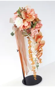 Cascading artificial orchid and rose wedding bridal bouquet with elegant ribbons for decoration.