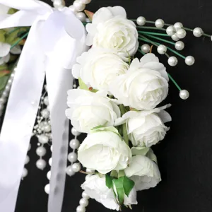 Bouquet da sposa artificiale bianco con rose, perle e nastro per la fotografia nuziale.