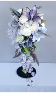 Splendido bouquet da sposa a cascata con gigli viola e peonie bianche per matrimoni.