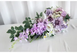 Detailansicht des kaskadierenden Brautstraußes, künstliche Blumen in Lila und Weiß für Hochzeit.