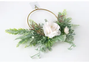 Detailansicht künstlicher Rosenblütenkranz mit goldenem Metallring und grünen Farnblättern.