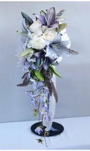 Vista dettagliata del bouquet da sposa artificiale a cascata con gigli blu e peonie bianche.