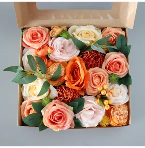 Primer plano de caja de regalo de rosas artificiales coloridas con hojas y flores.