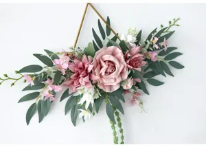 Detailansicht kuenstlicher rosa Rosen und Eukalyptusblaetter an geometrischer Eisen-Wanddeko.