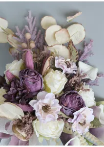 Detail view of European retro bridal hand bouquet with artificial burnt edge roses, wedding decor.