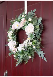 Vista detallada de corona de flores de rosas rosas artificiales con abundante follaje.