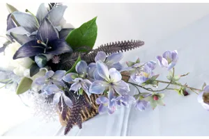 Squisito bouquet da sposa a cascata di gigli artificiali blu con dettagli nuziali.