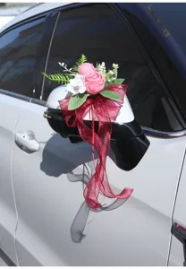 Wedding car mirror artificial flower decoration with red bow ribbon for ceremony decor.