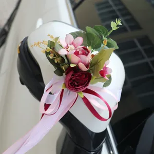 Kunstmatige bloemen boeket voor de achteruitkijkspiegel van de trouwauto met roze rozen.