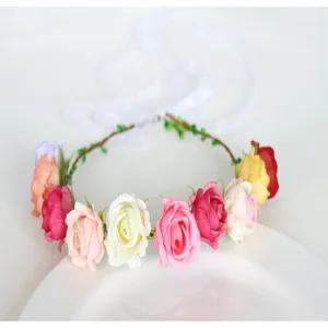 Detail shot of colorful artificial rose flower crown headband with white ribbons for photography.