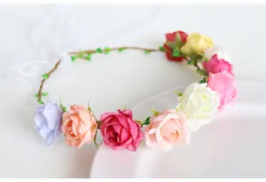 Detail view of a fairy-style floral crown with colorful artificial roses and white ribbon photo.