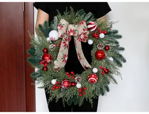 Ghirlanda decorativa di Natale con aghi di pino e palline rosse per porta e parete festa.