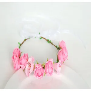 Closeup detail of the pink floral crown featuring delicate simulation roses and white ribbons for photo props.