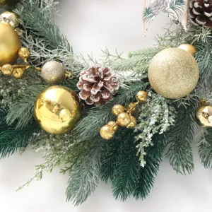 Ghirlanda di Natale con aghi di pino pigne e ornamenti dorati per decorazione porta.