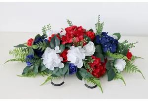 Detailansicht künstlicher rot-weiß-blauer Seidenblumen Friedhofs-Sattelgrab-Dekoration.